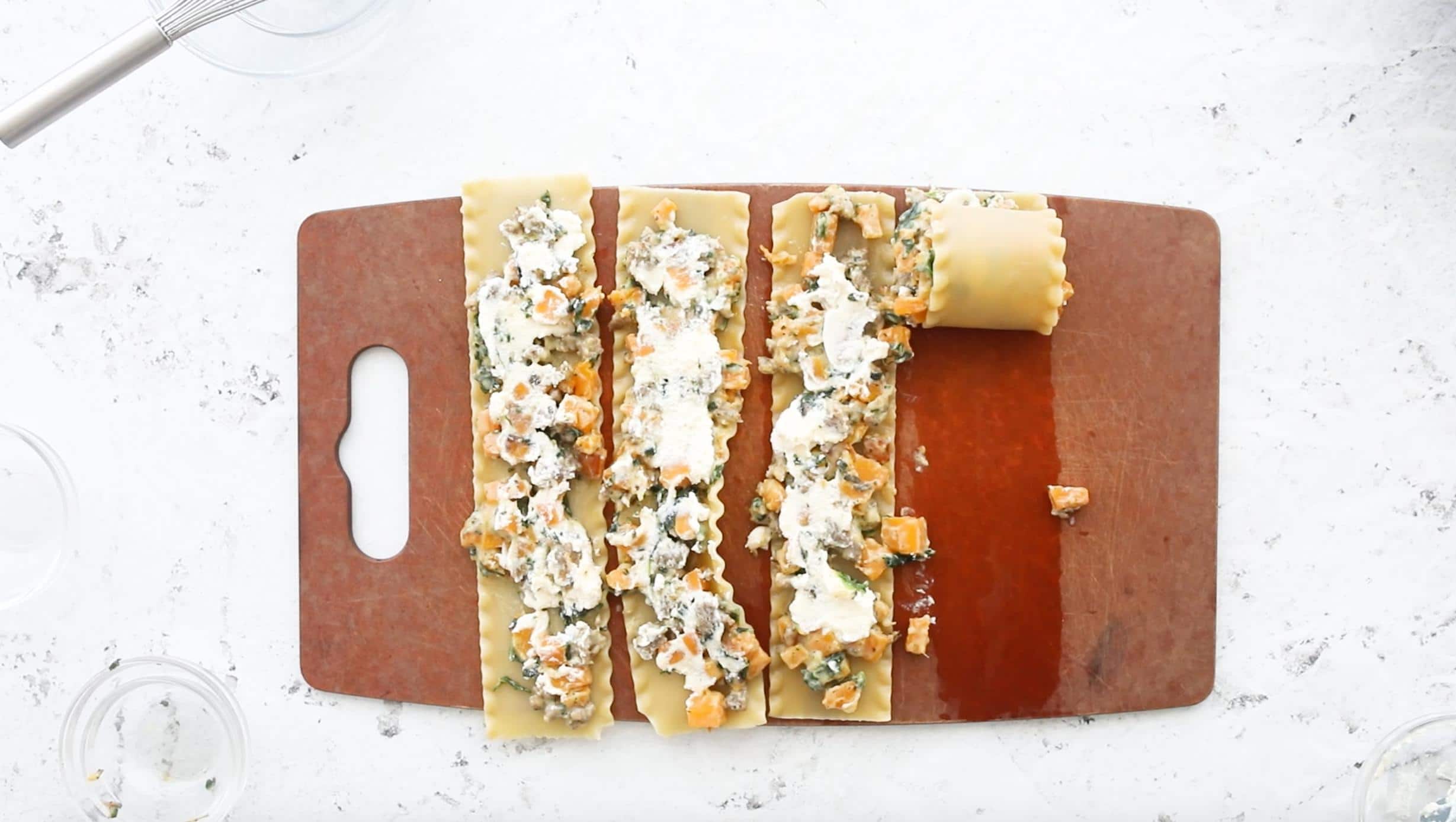 four butternut squash lasagna rolls on a cutting board