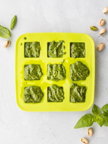 pistachio pesto in a green ice tray with ingredients around it