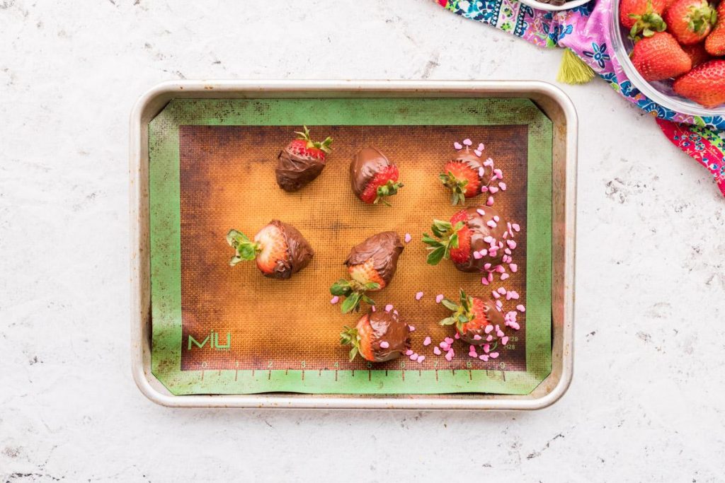 8 chocolate covered strawberries on a cookie sheet