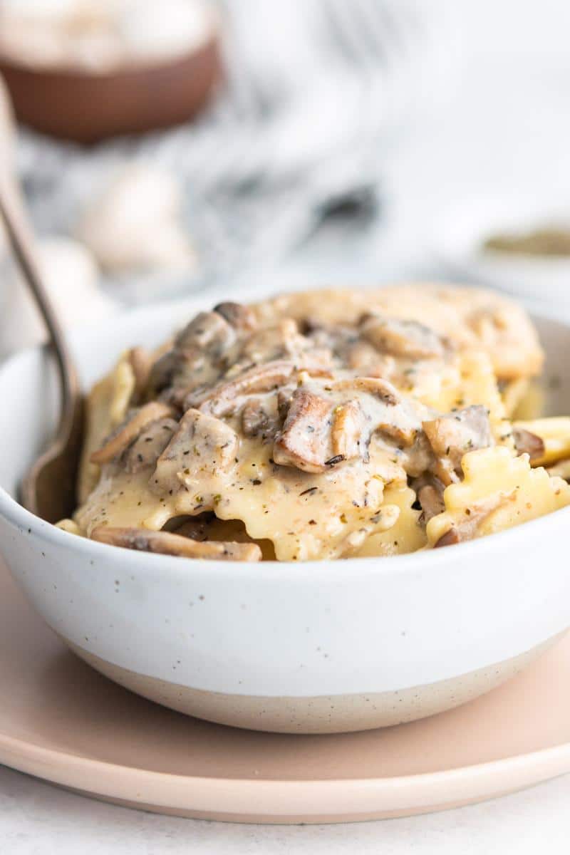 ravioli with mushroom ravioli sauce in a white bowl