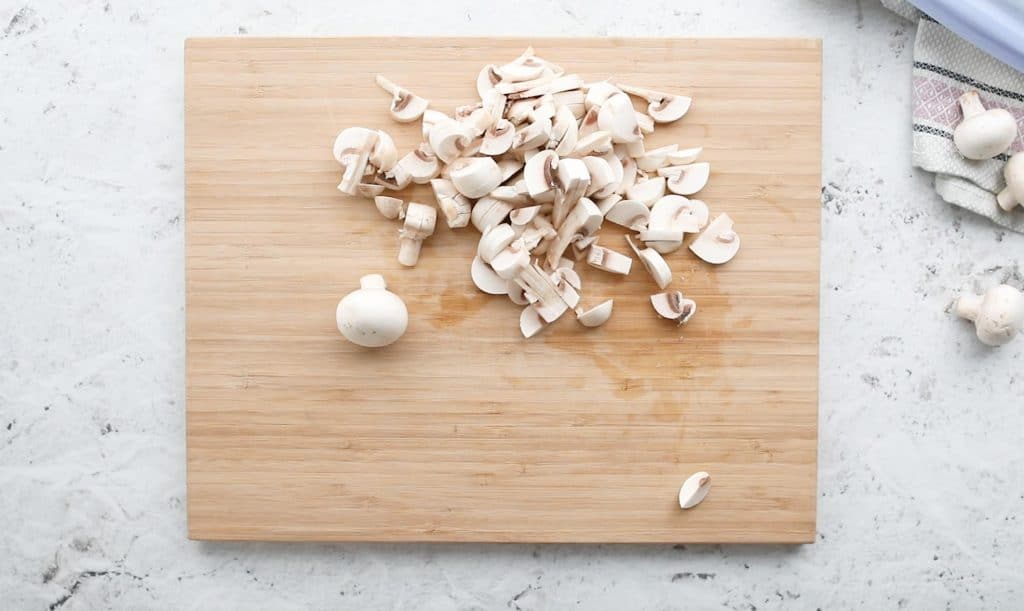 sliced mushrooms on a wooden cutting board