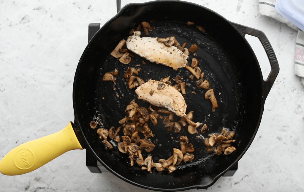 cooked mushrooms and chicken in a cast iron skillet