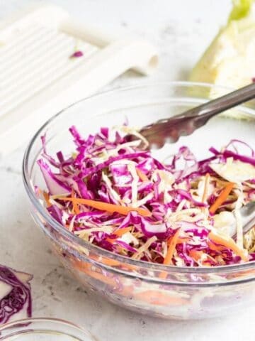 shredded cabbage and carrots in a glass bowl