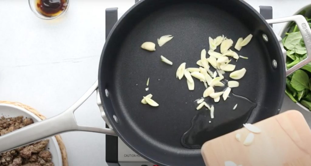 sliced garlic in a large black saucepan