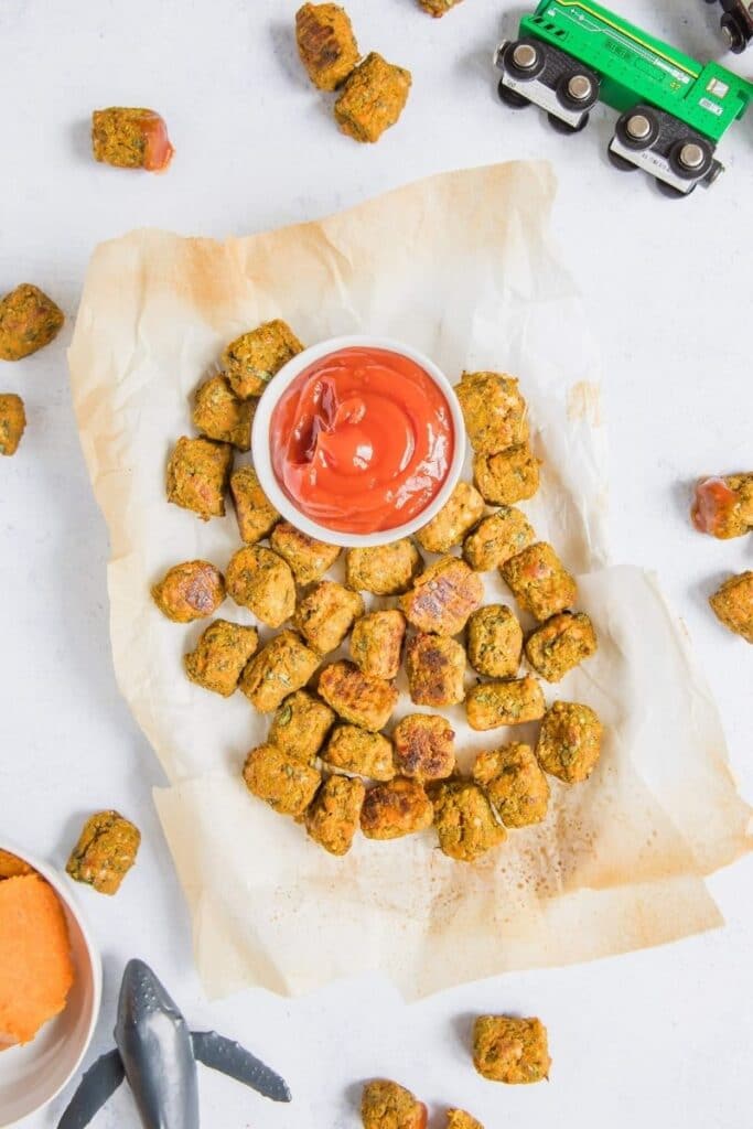tots on parchment paper with ketchup and toys around it
