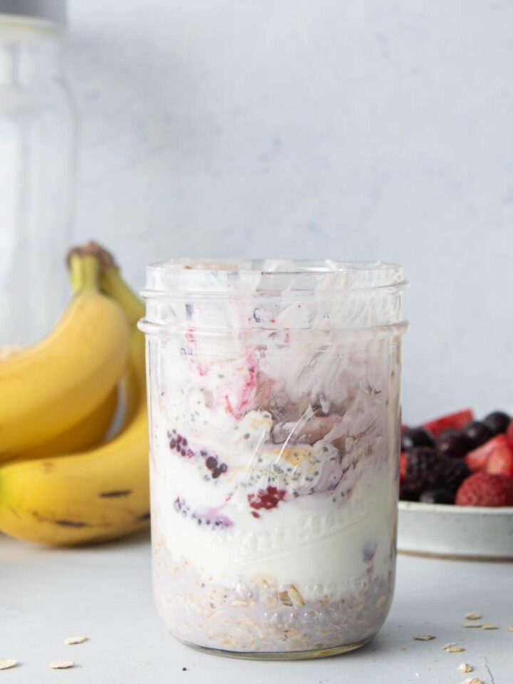 glass jar with oats, chia seeds, and frozen berries in it