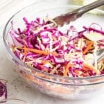 glass bowl of red and green cabbage and shredded carrots