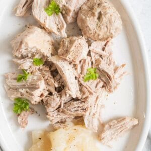 chunks of pulled pork on a platter with parsley