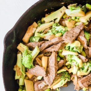 sliced beef and vegetables in a skillet