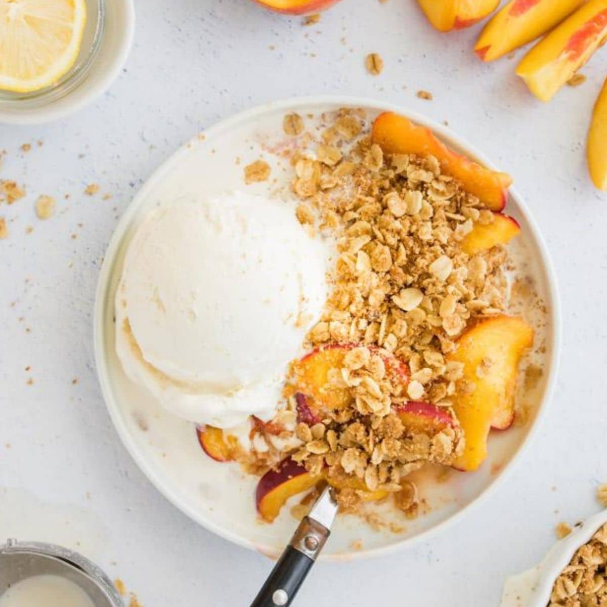 peach crisp with vanilla ice cream on a plate