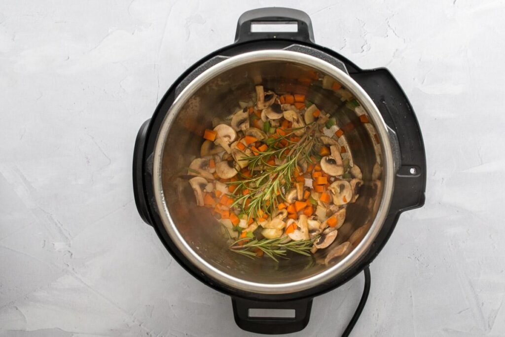 vegetables and rosemary sprigs in an Instant Pot