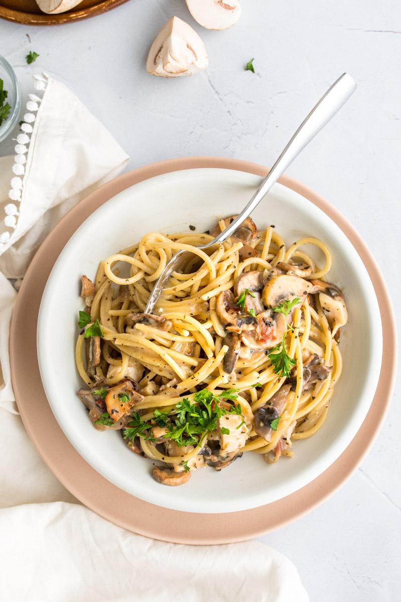 chicken bacon mushroom pasta on a pink plate