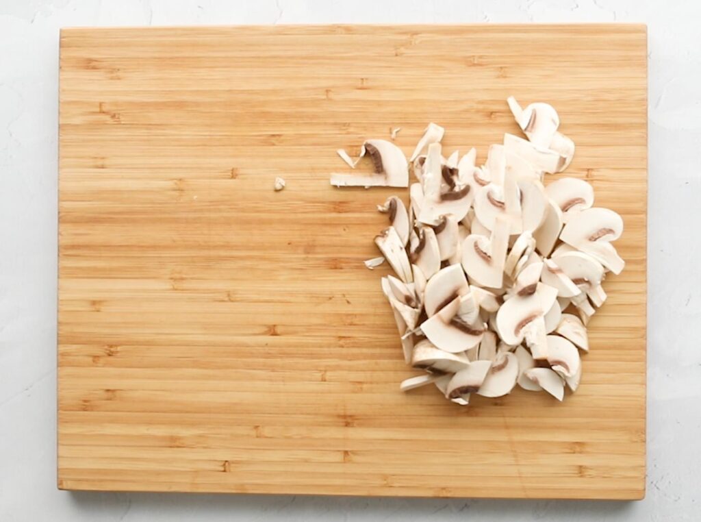 sliced mushrooms on a wooden cutting board