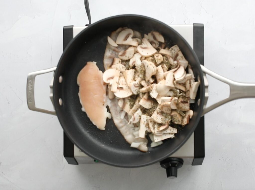 chicken tender, bacon, and mushrooms in a frying pan