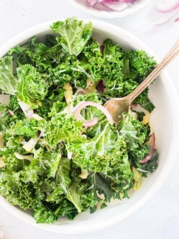 kale salad with red onions in a bowl