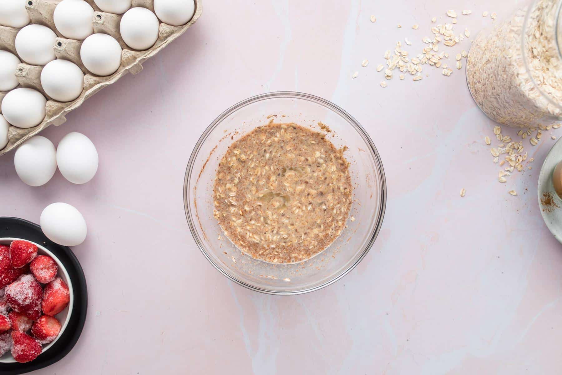 uncooked oats, spices, and an egg in a glass bowl