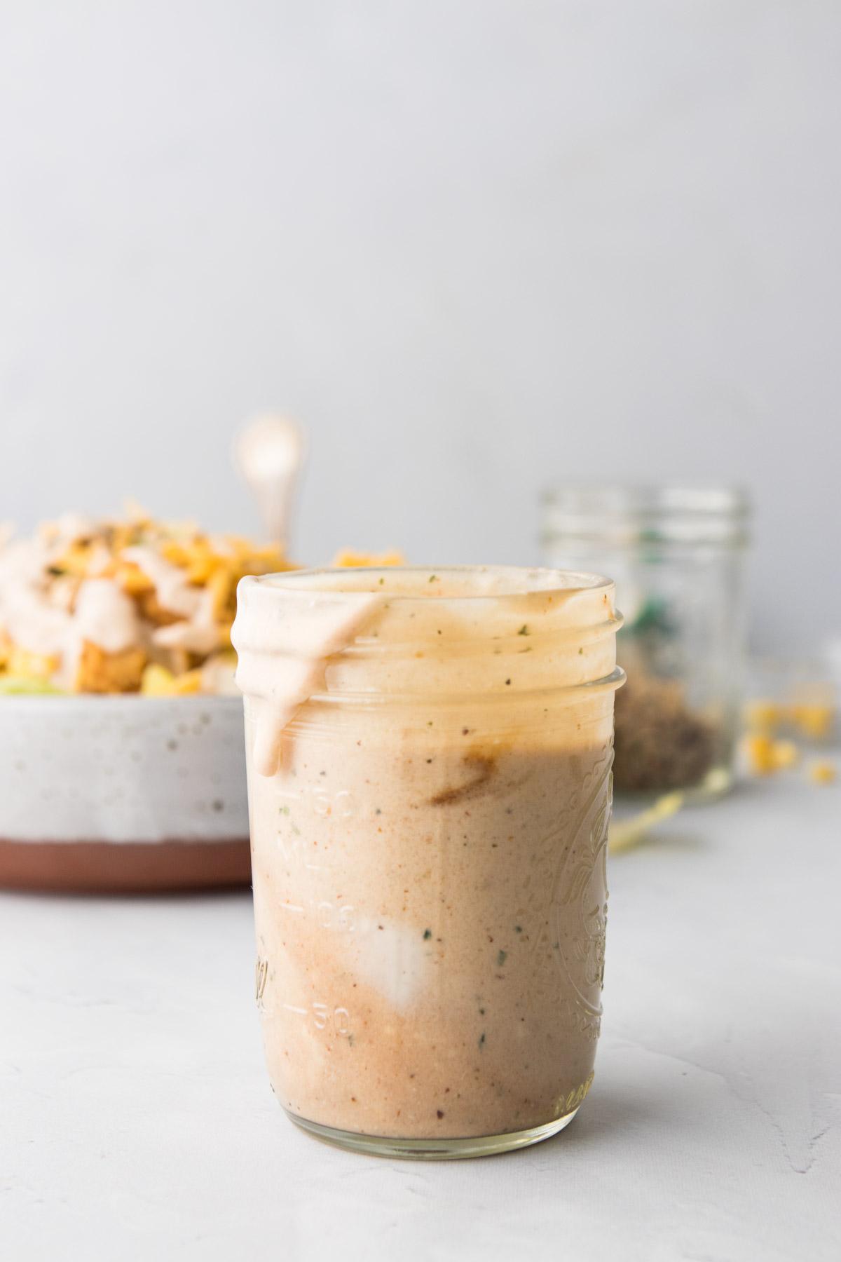 BBQ ranch dressing in a jar with salad in the background