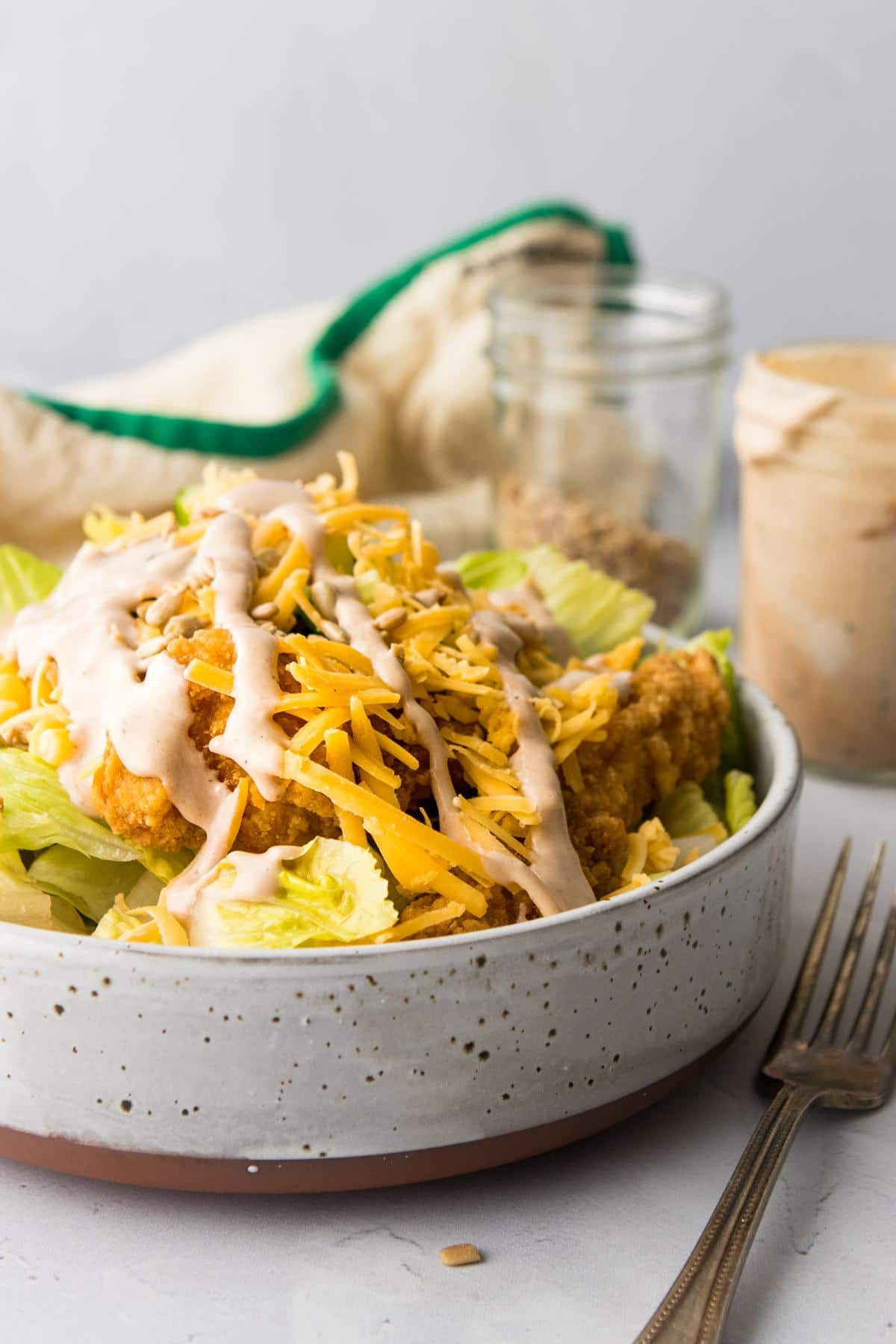 chicken, shredded cheese, and vegetable salad in a grey bowl