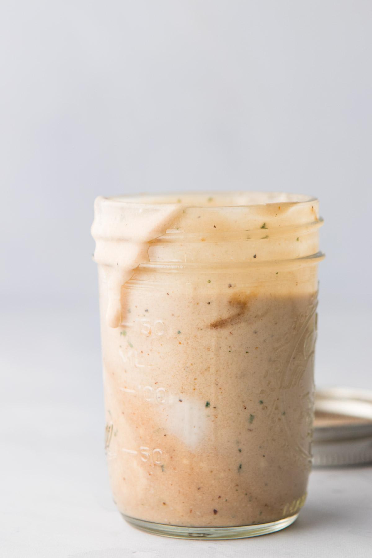 close up photo of barbecue ranch dressing in a glass jar