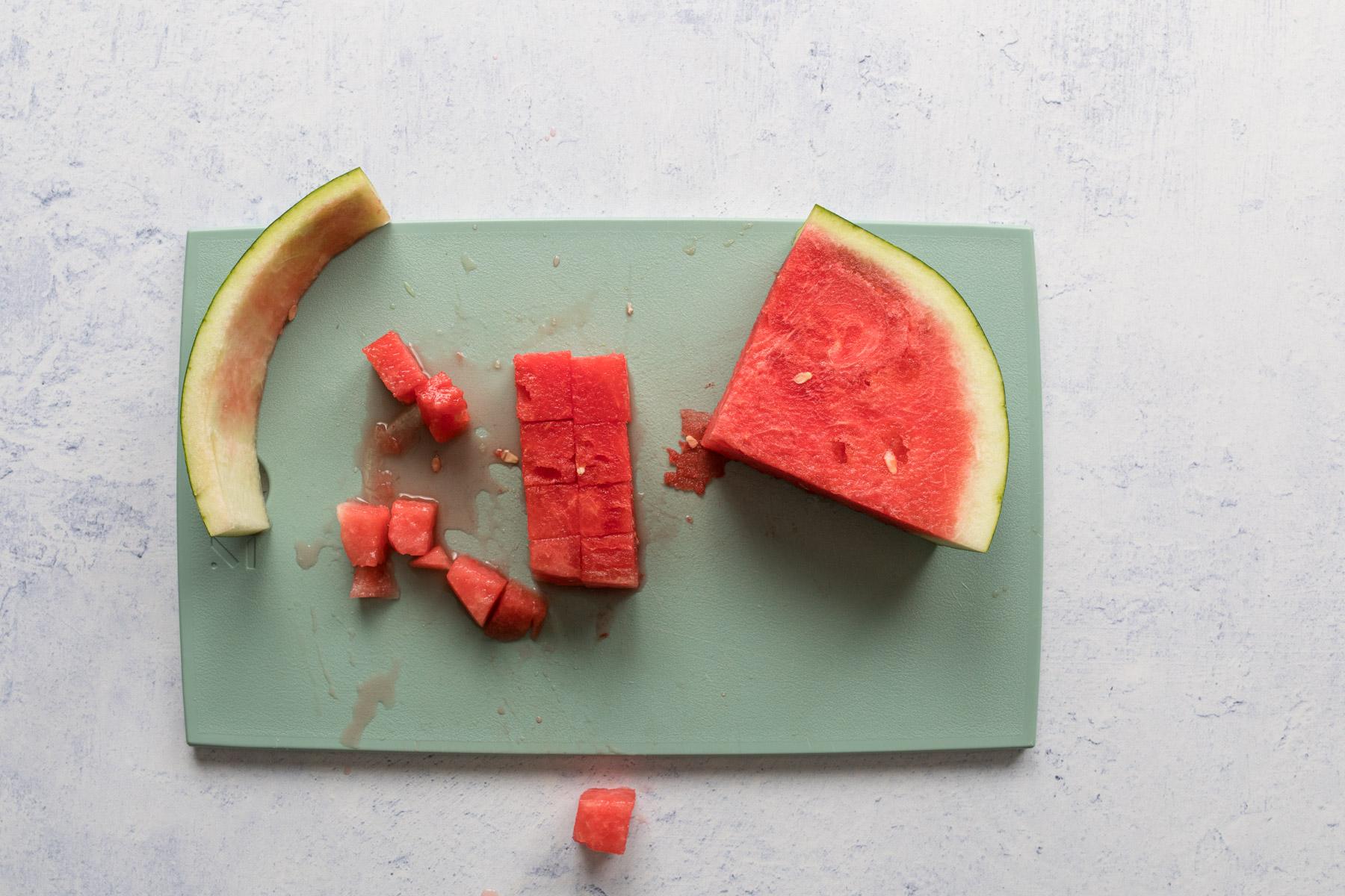 cut watermelon on a green cutting board