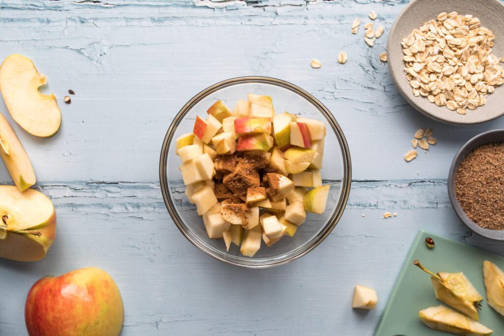 chopped apples and cinnamon in glass bowl