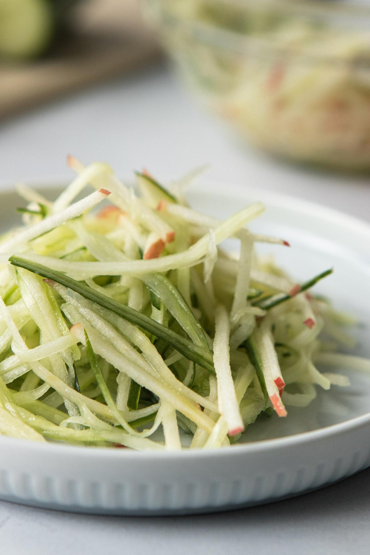 thinly sliced apples and cucumbers on a blue plate