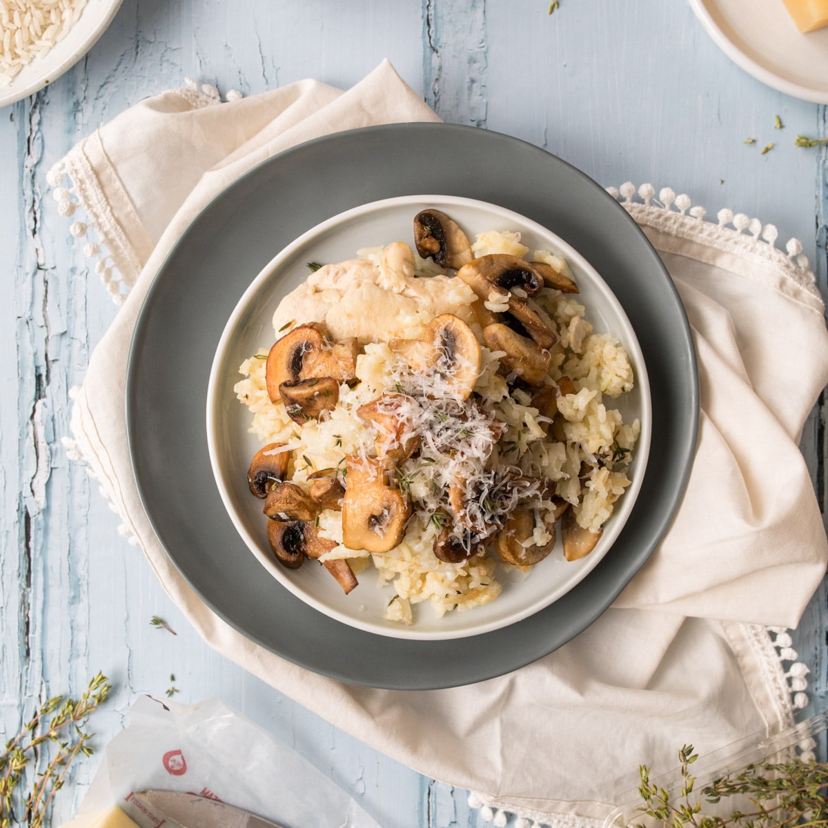 mushrooms and chicken over rice on a white and grey plate