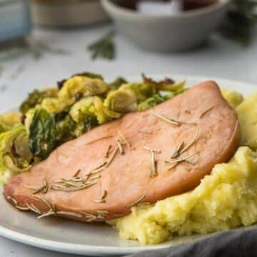 square image of ham and veggies on the side