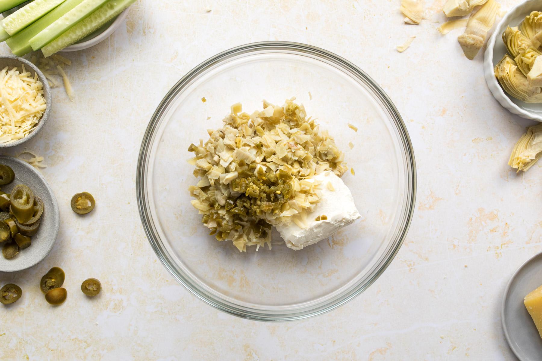 cream cheese, chopped artichokes and jalapenos in bowl