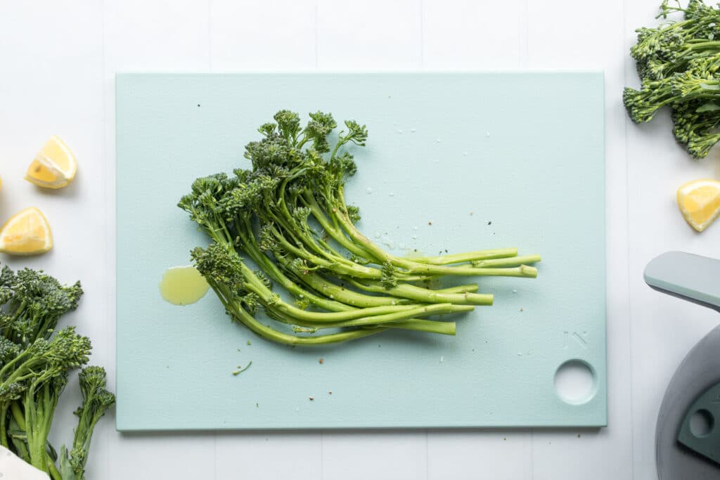 broccolini with oil on cutting board
