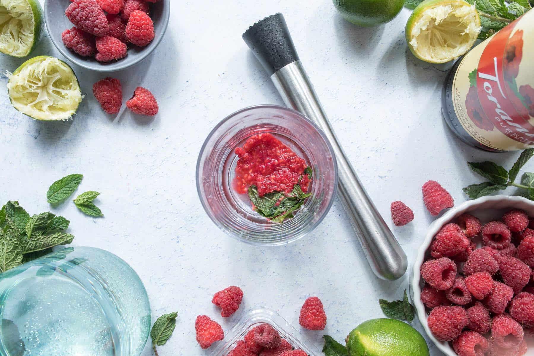 mashed raspberries and mint in glass