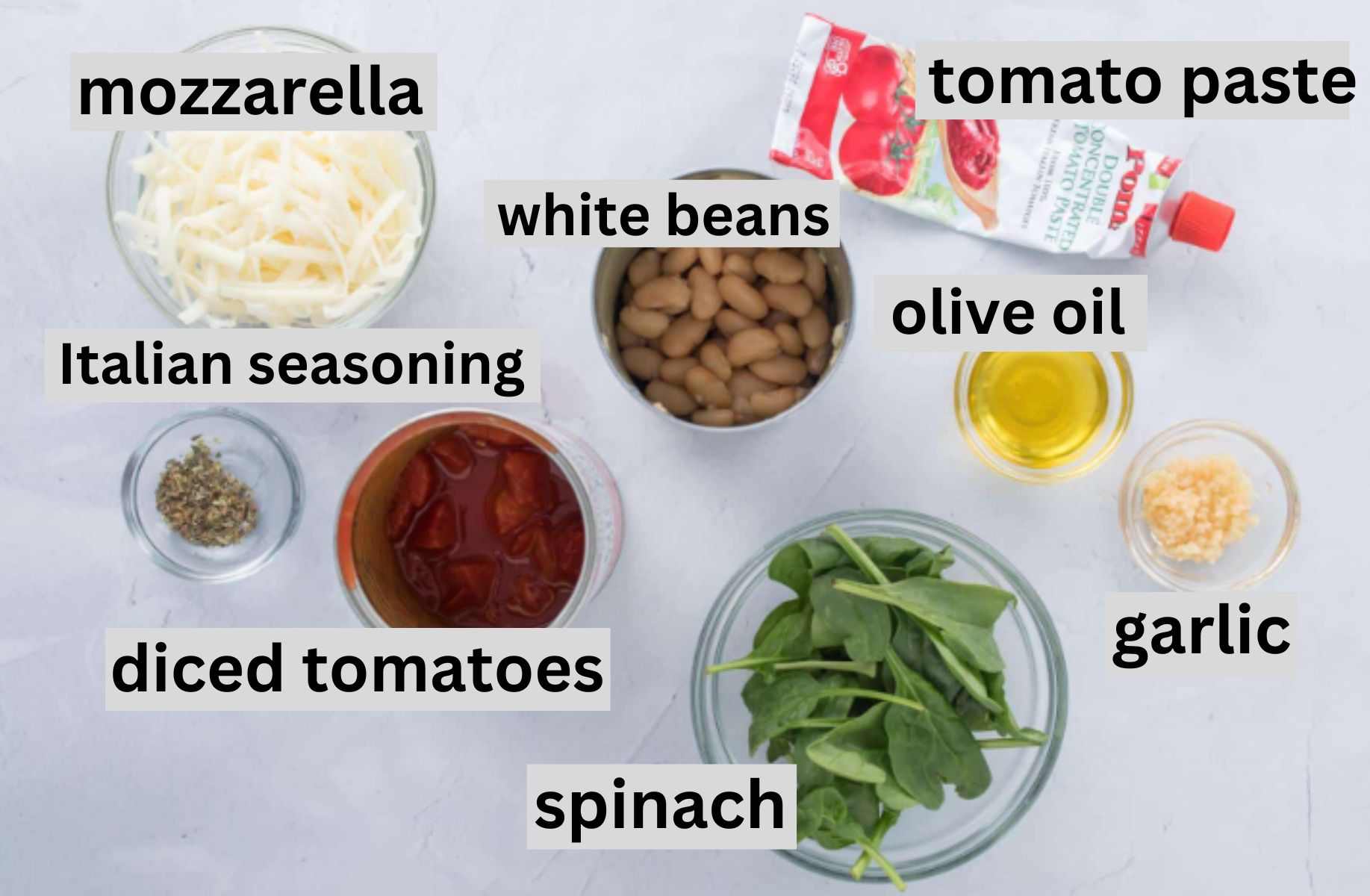 white beans, tomatoes, spinach, other ingredients on table