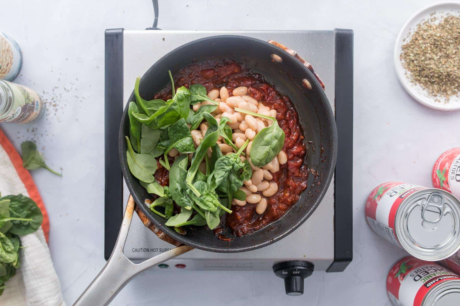 tomatoes, beans, spinach in skillet
