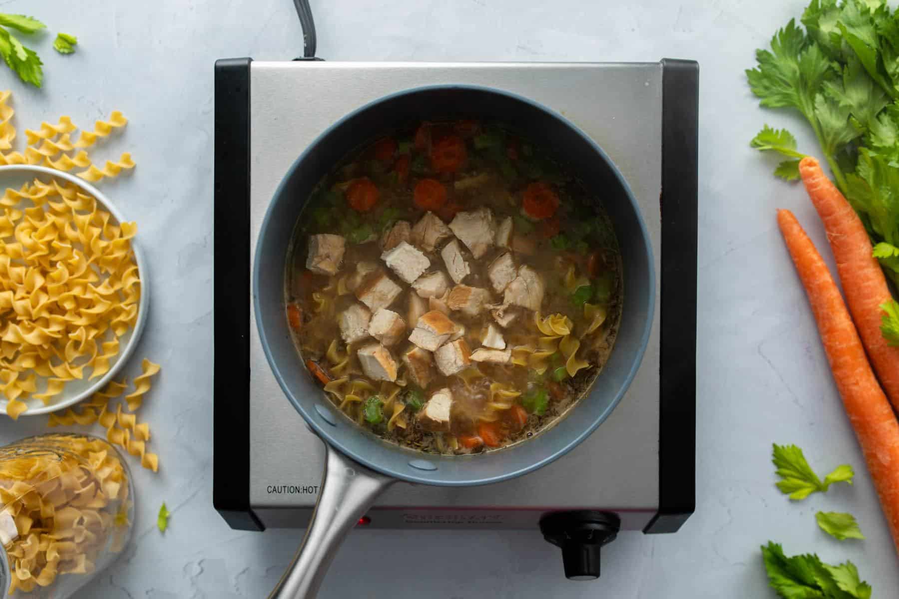 chopped chicken and vegetable soup in pot