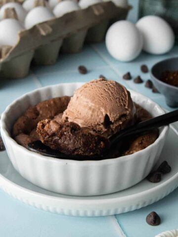 spoonful of brownie in ramekin with ice cream