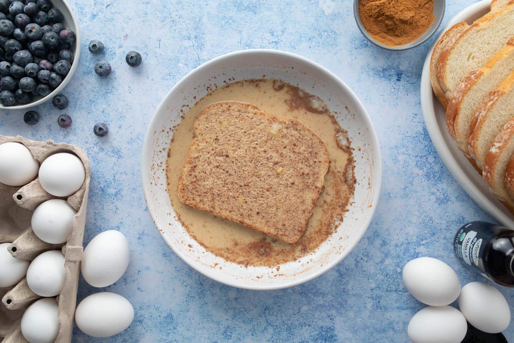 bread slice soaking in cinnamon milk mixture