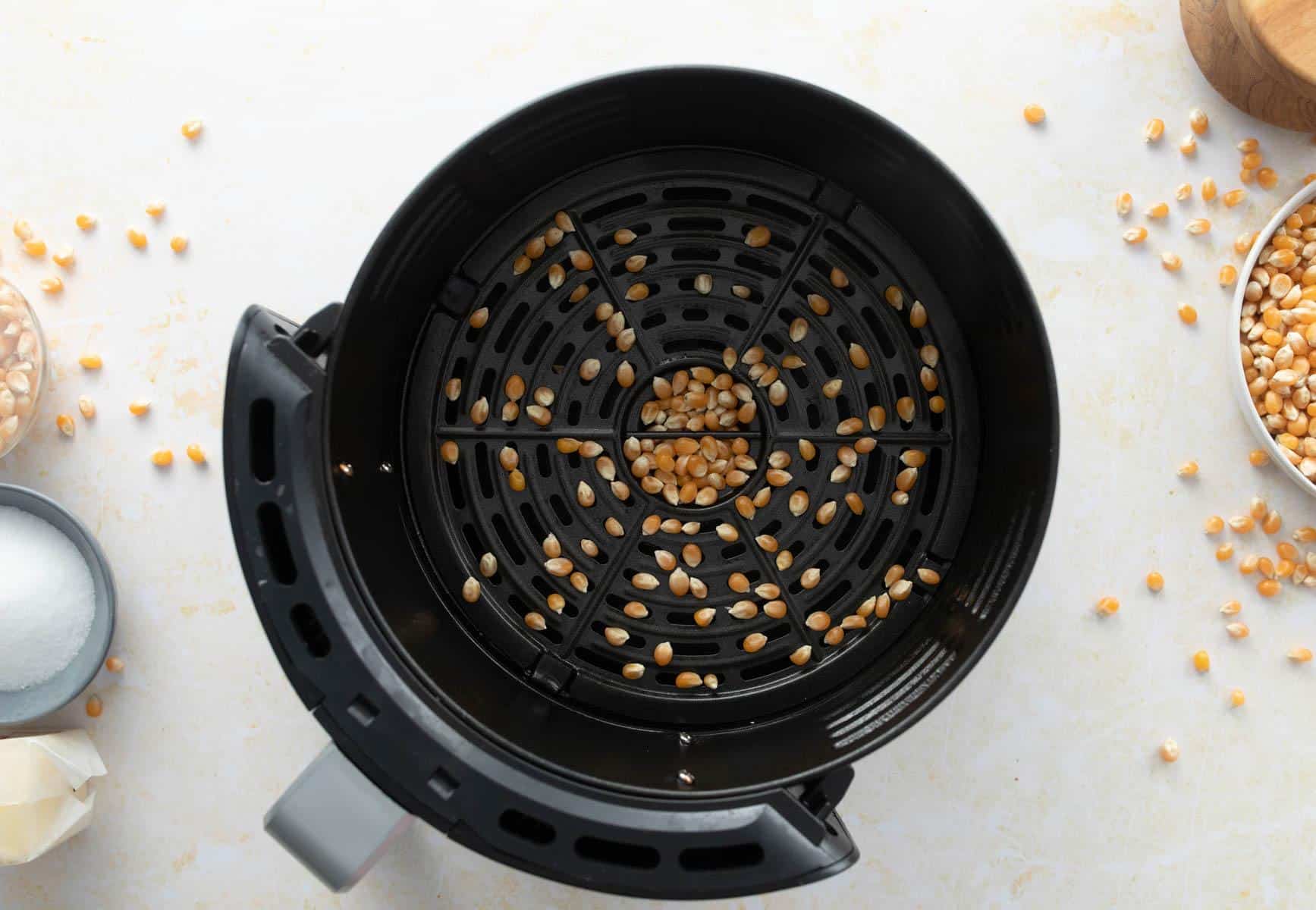 air fryer basket with popcorn kernels in it