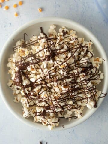 white bowl of chocolate drizzled popcorn