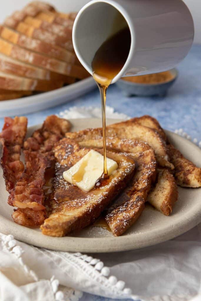 pouring syrup onto french toast