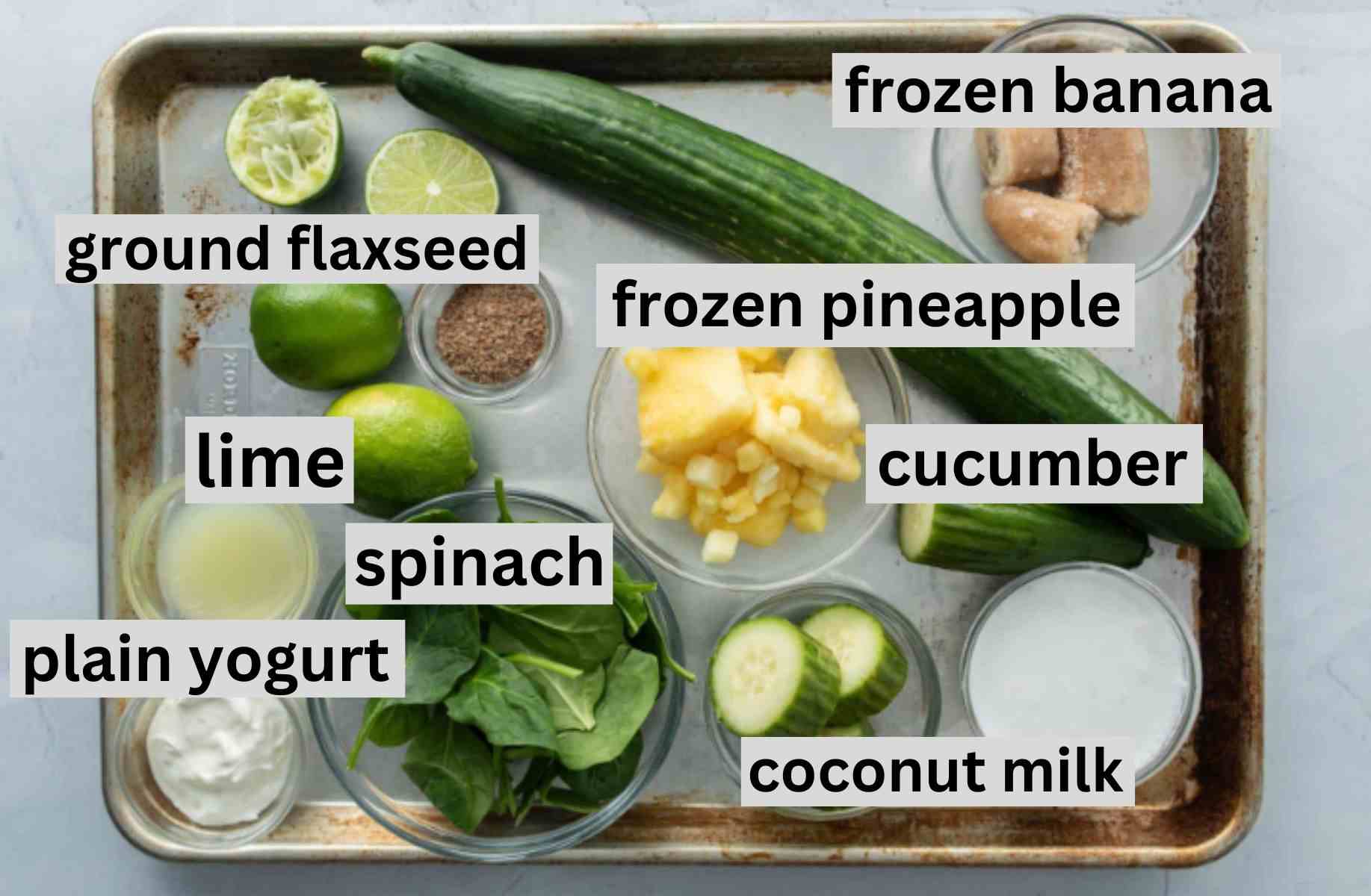 spinach, cucumber, pineapple, other ingredients on baking sheet