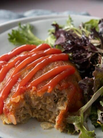 bite out of meatloaf with ketchup and salad