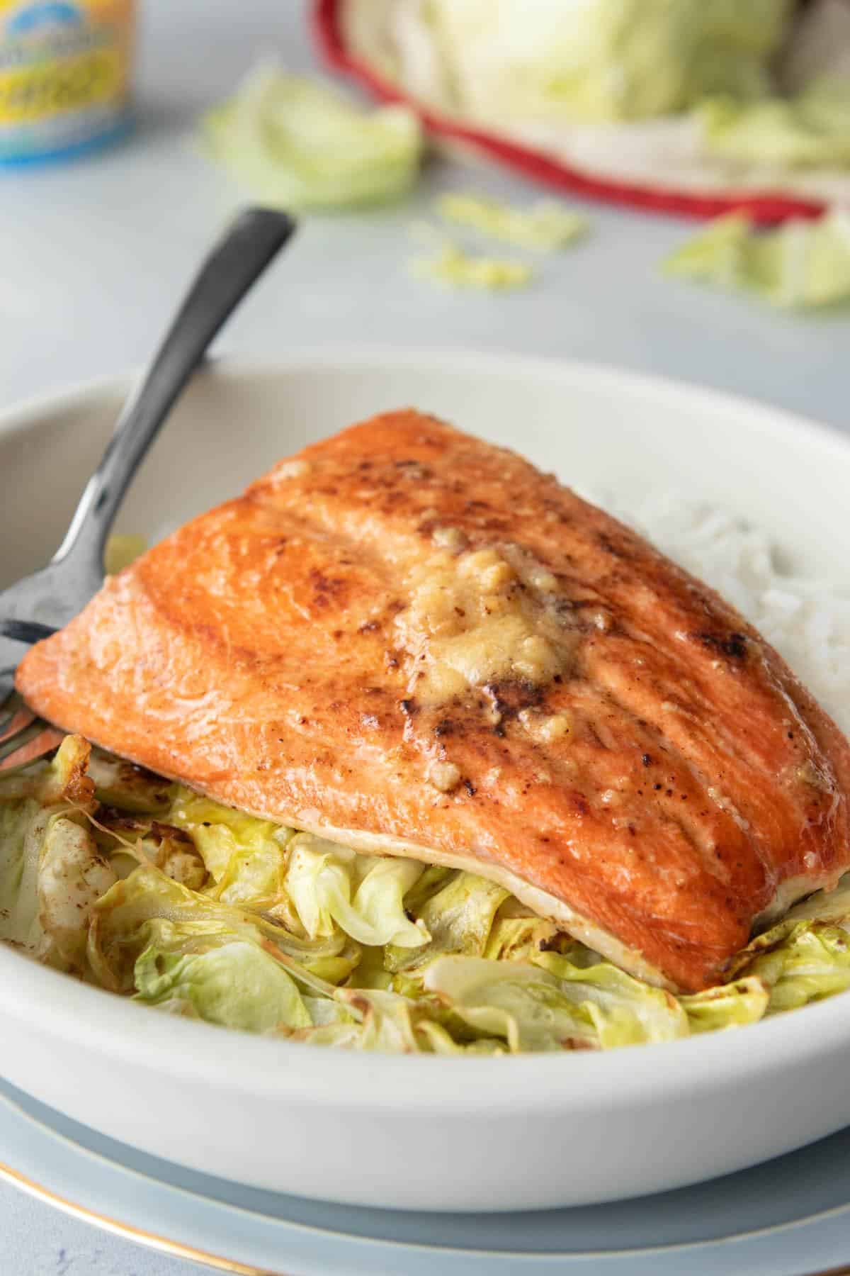 salmon with sauce on top of cabbage