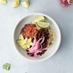 rice and beans, onions, salsa, avocado, lime wedges in bowl