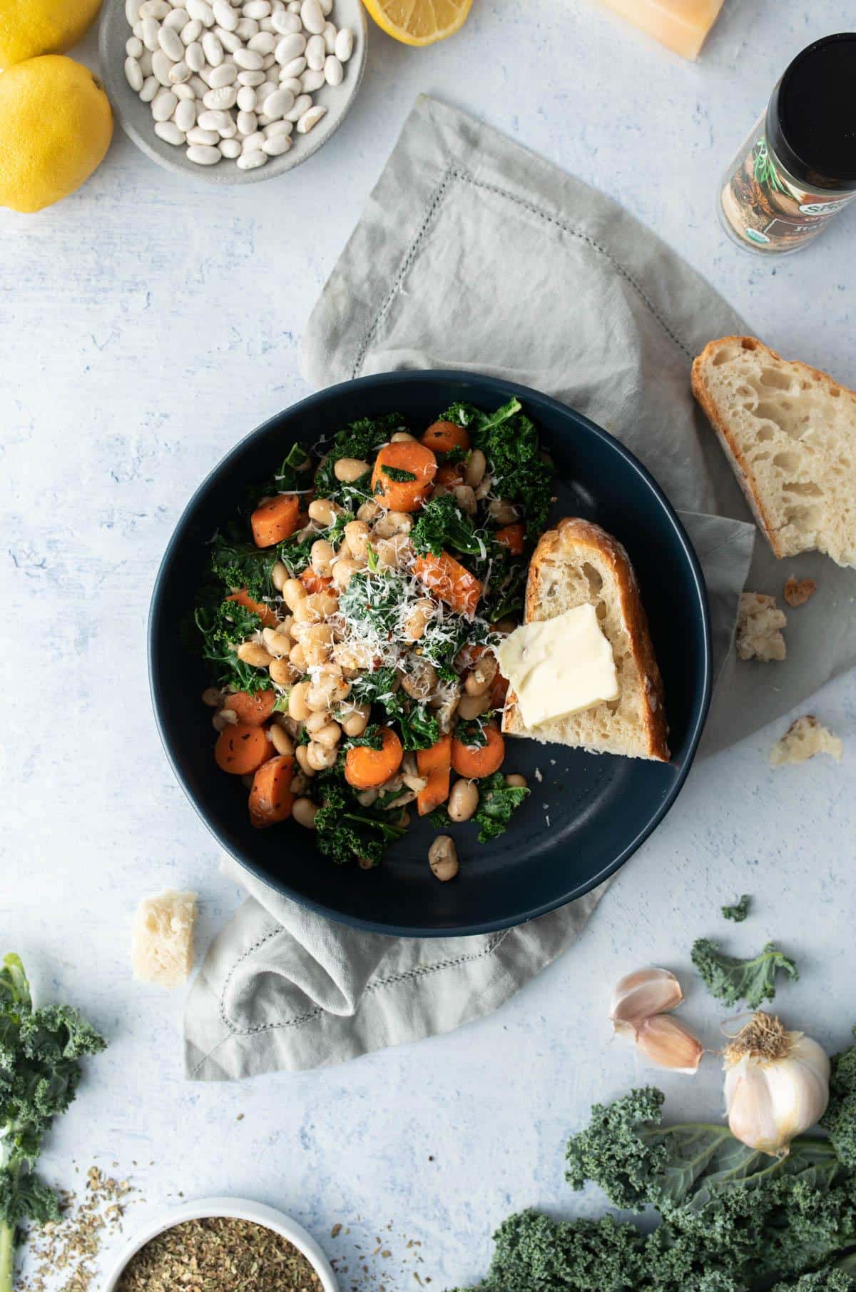 blue bowl with Italian beans and vegetables, bread in it
