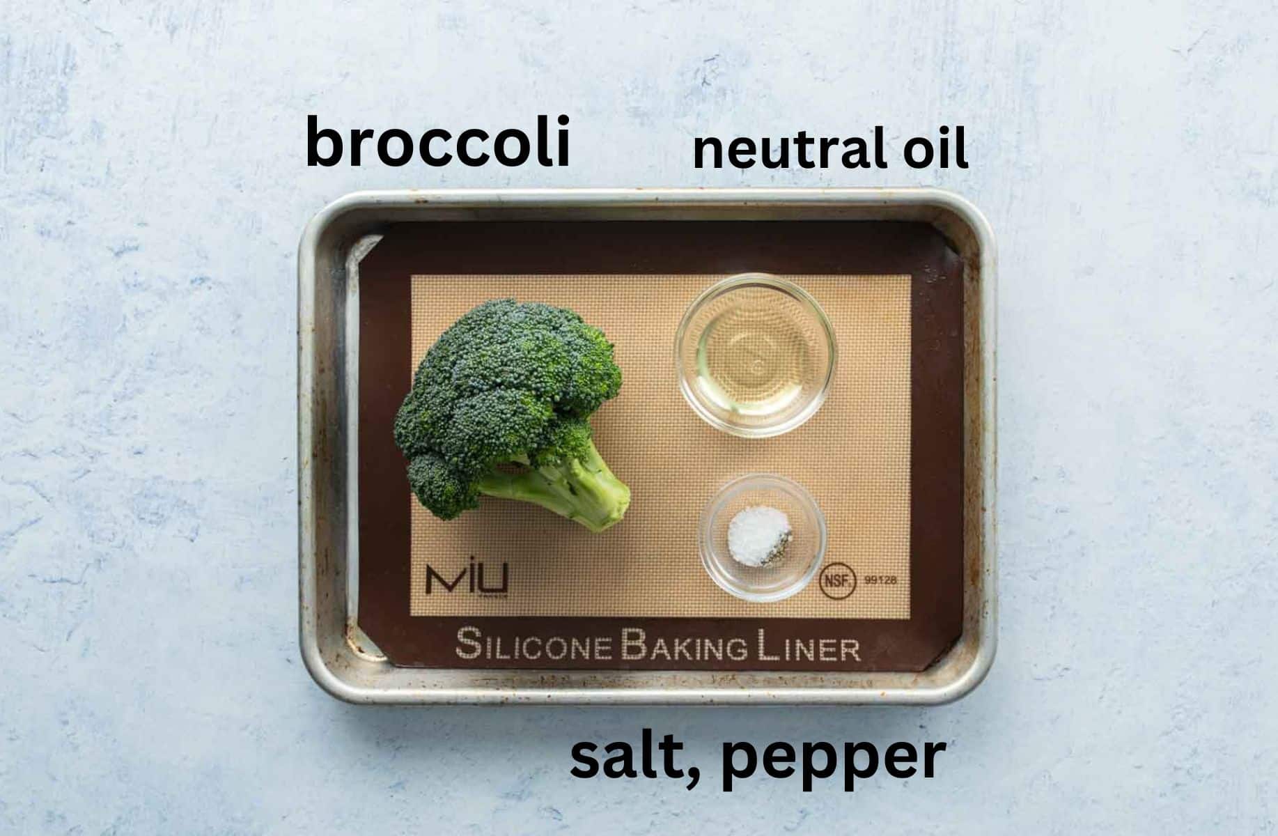 broccoli crowns, seasonings, and oil on baking sheet