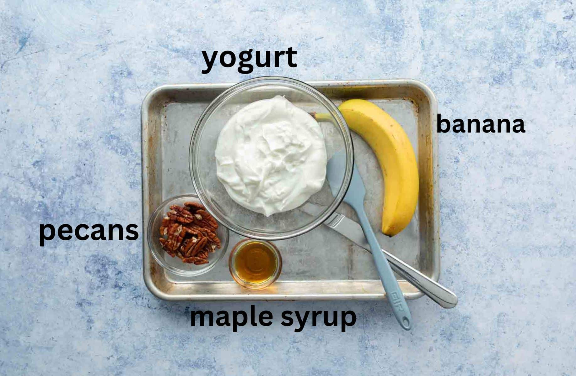 yogurt, banana, nuts, syrup on baking sheet with labels