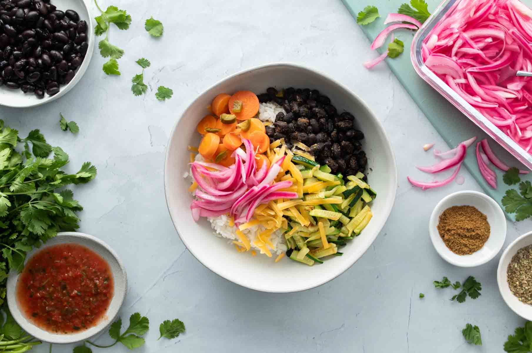 colorful vegetables, black beans over rice in a bowl