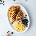 four waffle quarters, eggs, blueberries on plate