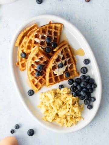 four waffle quarters, eggs, blueberries on plate