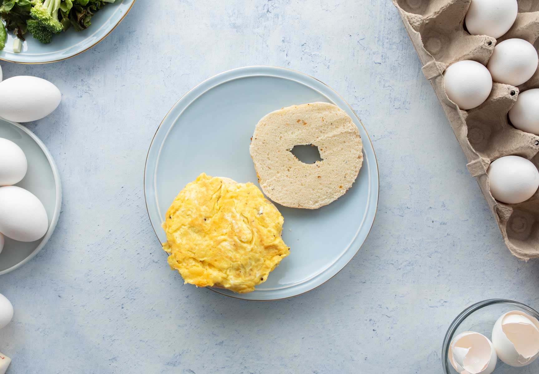 eggs and bagel slice on blue plate